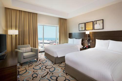a hotel room with two beds and a television at Residence Inn by Marriott Jazan in Jazan
