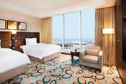 a hotel room with two beds and a chair at Residence Inn by Marriott Jazan in Jazan