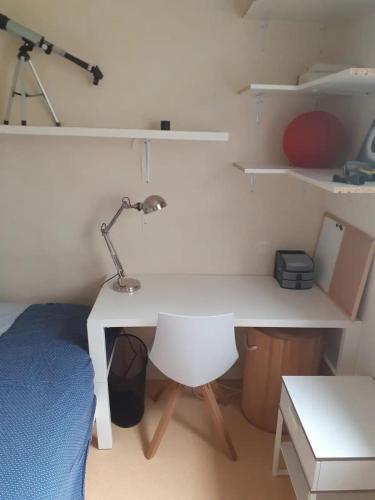 - un bureau avec une lampe et un lit dans une chambre dans l'établissement Chambre au calme près du centre historique de Vannes, à Vannes