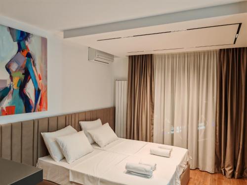 a bedroom with a bed with two towels on it at Planet Lux Apartment in Niš