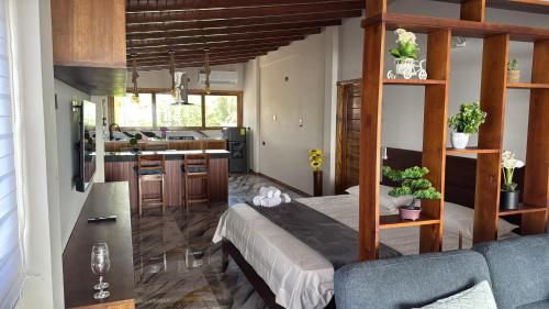 a living room with a bed and a kitchen at Las Olas del Surf in Ayampe