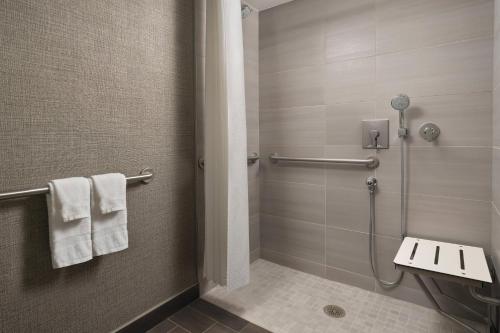 a bathroom with a shower and a toilet and towels at Warner Center Marriott Woodland Hills in Woodland Hills