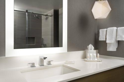 a bathroom with a white sink and a mirror at Warner Center Marriott Woodland Hills in Woodland Hills