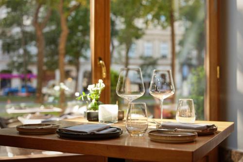 a wooden table with wine glasses and chargers on it at The Ritz-Carlton, Vienna in Vienna