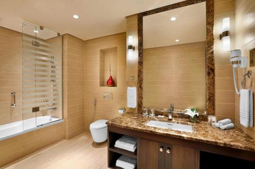 a bathroom with a sink and a tub and a toilet at Residence Inn by Marriott Jazan in Jazan