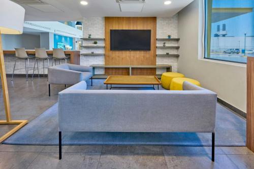 a living room with a couch and a tv at City Express by Marriott Mexicali in Mexicali