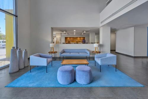 a lobby with blue furniture and a table and chairs at City Express by Marriott Mexicali in Mexicali