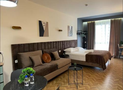 un soggiorno con un divano e un letto di Luxury Suite Studio City Centre a Tirana