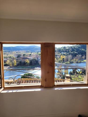 a window in a room with a view of a river at La maison de Consuelo in Roquebrun