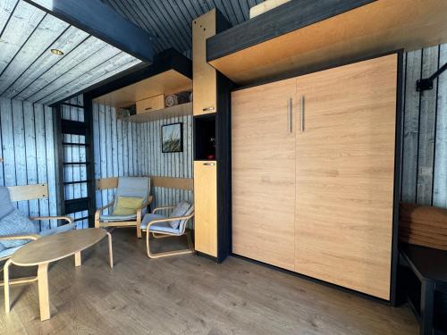a room with a large wooden door with chairs and a table at Jūras Krasti Bohemija in Jūrmalciems