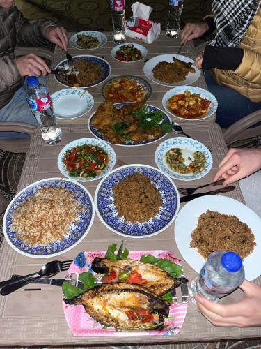 a group of people sitting around a table full of food at Four pyramids View Guest house in Cairo