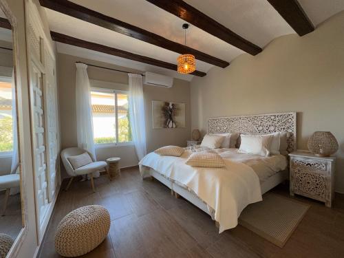 a bedroom with a large bed and a chair at Casa del Rebaldi in Jávea