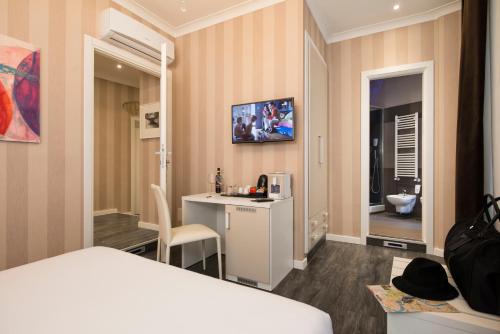 a hotel room with a television and a bed at San Pietro Suites in Rome
