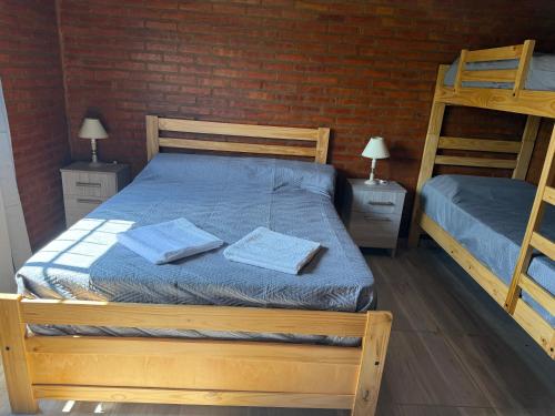 een slaapkamer met 2 stapelbedden en een bakstenen muur bij Cabañas AdamiS in Villa Cura Brochero
