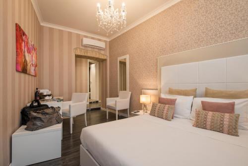 1 dormitorio con 1 cama grande, mesa y sillas en San Pietro Suites, en Roma