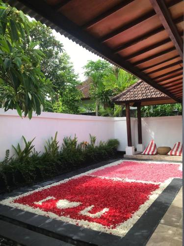 a carpet of red flowers on a patio at One BedRoom Villa with Private Pool near DPS Airport in Kuta