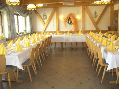 a large room with tables and chairs with yellow napkins at Landgasthaus Löwen mit Gästehaus in Holzhausen