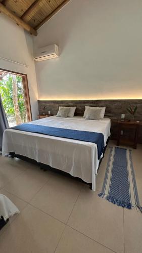 a bedroom with a large bed with a blue blanket at Casa das Alpinias - Trancoso in Trancoso