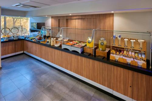 a restaurant with a counter with food and drinks at City Express by Marriott Celaya Galerias in Celaya
