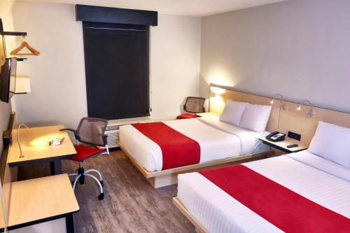 a hotel room with two beds and a desk at City Express by Marriott Celaya Galerias in Celaya
