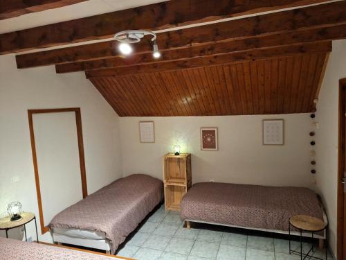 MoyeにあるGîte Le Parmandの木製の天井の部屋にベッドが2つある