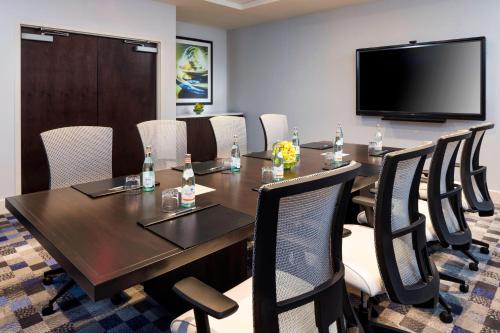 a conference room with a table and chairs and a flat screen tv at Sheraton Bloomington in Bloomington