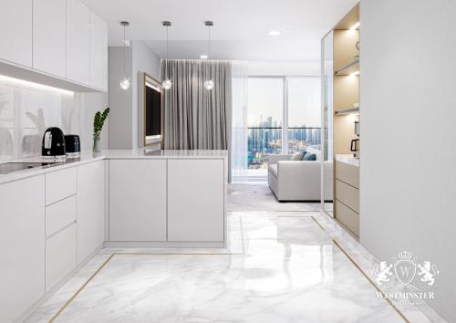 a kitchen with white cabinets and a living room at Westminster Dubai Mall in Dubai