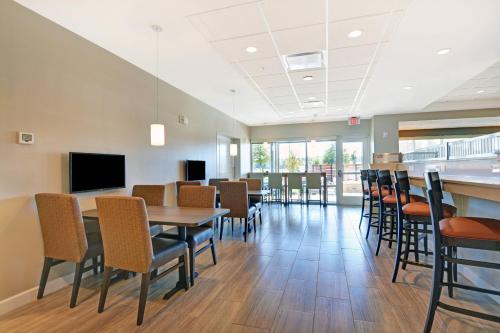 a dining room with tables and chairs and a flat screen tv at TownePlace Suites by Marriott Jackson Airport/Flowood in Flowood