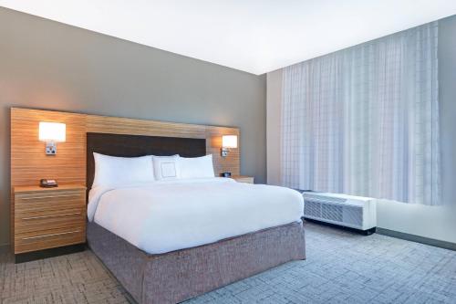 a bedroom with a large bed and a large window at TownePlace Suites by Marriott Jackson Airport/Flowood in Flowood