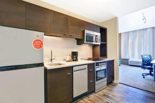 a kitchen with a refrigerator and a sink at TownePlace Suites by Marriott Jackson Airport/Flowood in Flowood