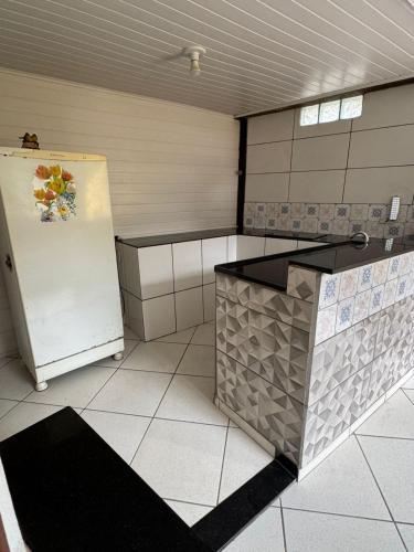 a kitchen with a refrigerator and a tile floor at Pousada do Sossego in Conceição da Ibitipoca