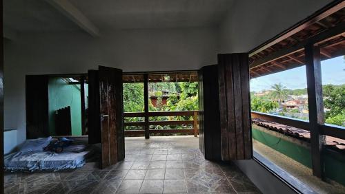 a room with doors open to a room with a balcony at LahSelva Pousada e Hostel in Itacaré