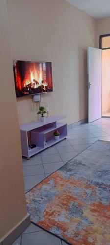 a living room with a tv on a wall at Lablu Studio Apartment in Mombasa