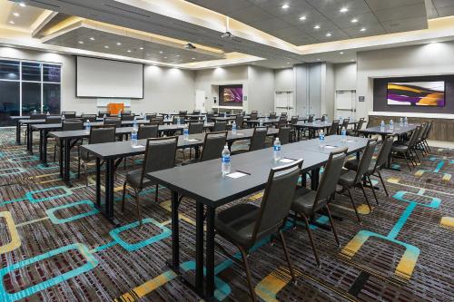 a conference room with tables and chairs and a projection screen at Residence Inn by Marriott Houston West/Beltway 8 at Clay Road in Houston