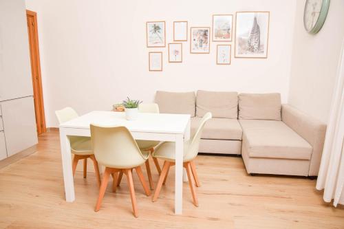 een witte tafel en stoelen in een woonkamer met een bank bij Anna’s Home in Pompei