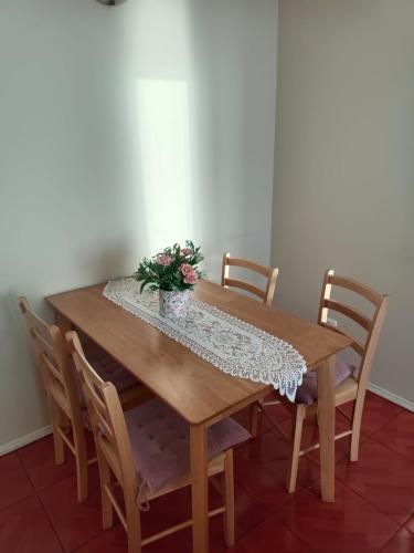 a wooden table with chairs and a vase of flowers on it at Departamento frente a playa Bellavista in Tomé