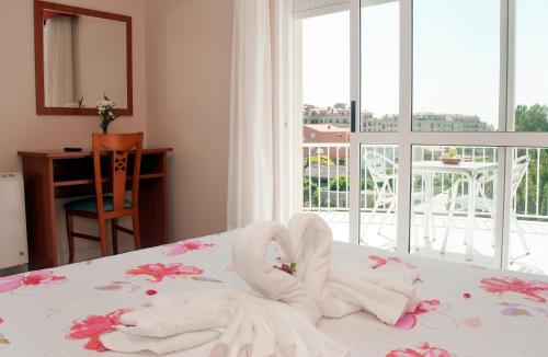 a bedroom with a bed with two swans made out of towels at Hotel Ria Toxa in Revolta