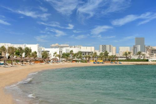 a beach with chaise lounges and hotels at Sharq Village & Spa, a Ritz-Carlton Hotel in Doha