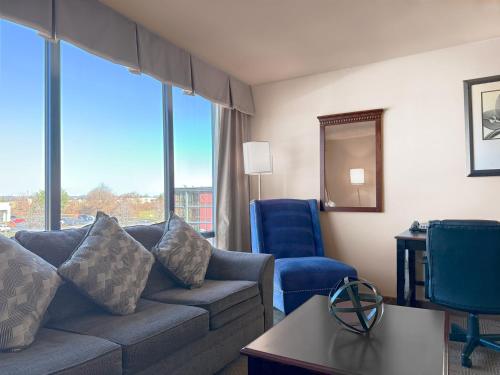 a living room with a couch and chairs and a large window at Holiday Inn South Plainfield-Piscataway by IHG in South Plainfield