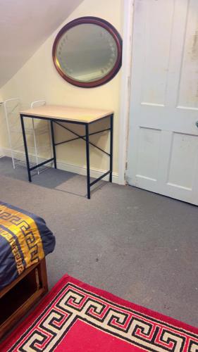 a room with a table and a mirror on the wall at Bronze Bachelor Room in Slough