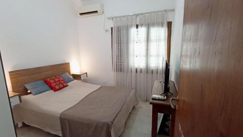 a small bedroom with a bed and a window at Amplios Departamentos en Corrientes in Corrientes