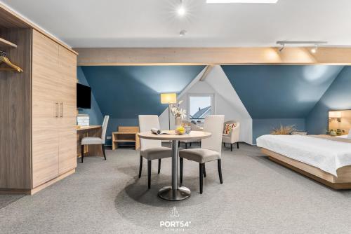 a bedroom with a bed and a table and chairs at Ferienwohnung Bude 14 Dagebüll in Dagebüll