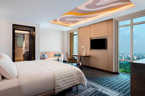 a hotel room with a bed and a view of the city at Le Meridien Dhaka in Dhaka