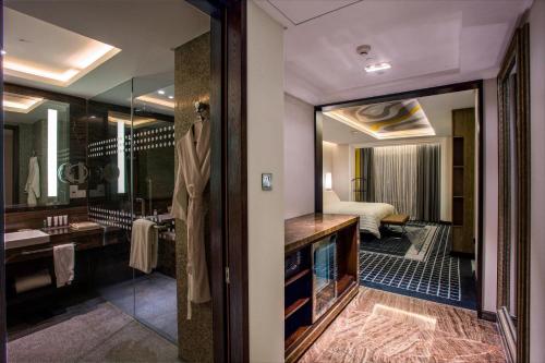 a bathroom with a large mirror and a sink at Le Meridien Dhaka in Dhaka