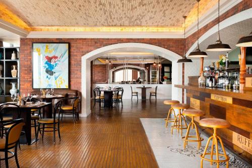 a restaurant with tables and chairs in a room at Le Meridien Dhaka in Dhaka