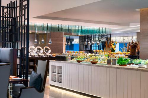 a restaurant with a buffet of food on a counter at Le Meridien Dhaka in Dhaka