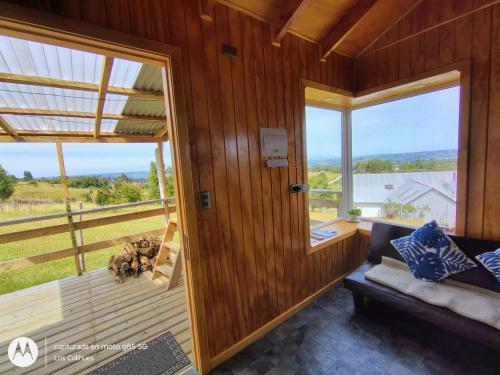 a living room with a couch and a large window at Agroturismo los Colihues 2 in Castro