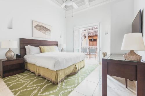 a bedroom with a bed and a desk and a desk at Casa La Cartujita in Cartagena de Indias