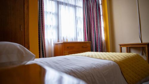 a bedroom with a bed in front of a window at Hotel Cima Argentum in Potosí