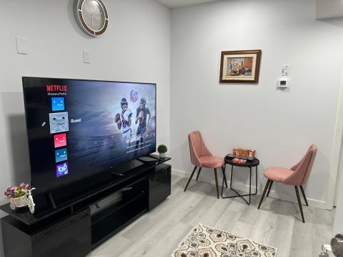 a living room with a large flat screen tv at Muaysh Cozy Family suite - Londonderry Mall in Edmonton